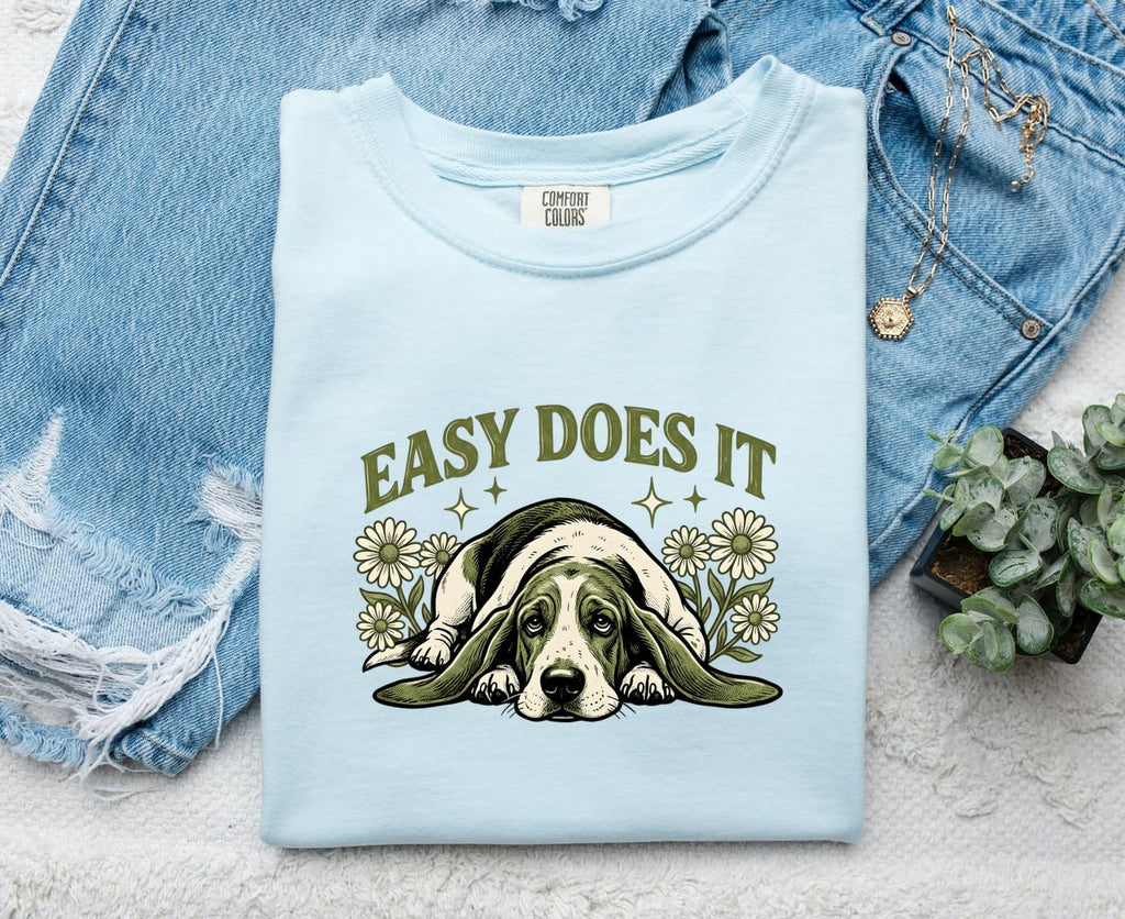 Chambray Comfort Colors 1717 t-shirt with a dog graphic and 'Easy Does It' text, folded on denim fabric.
