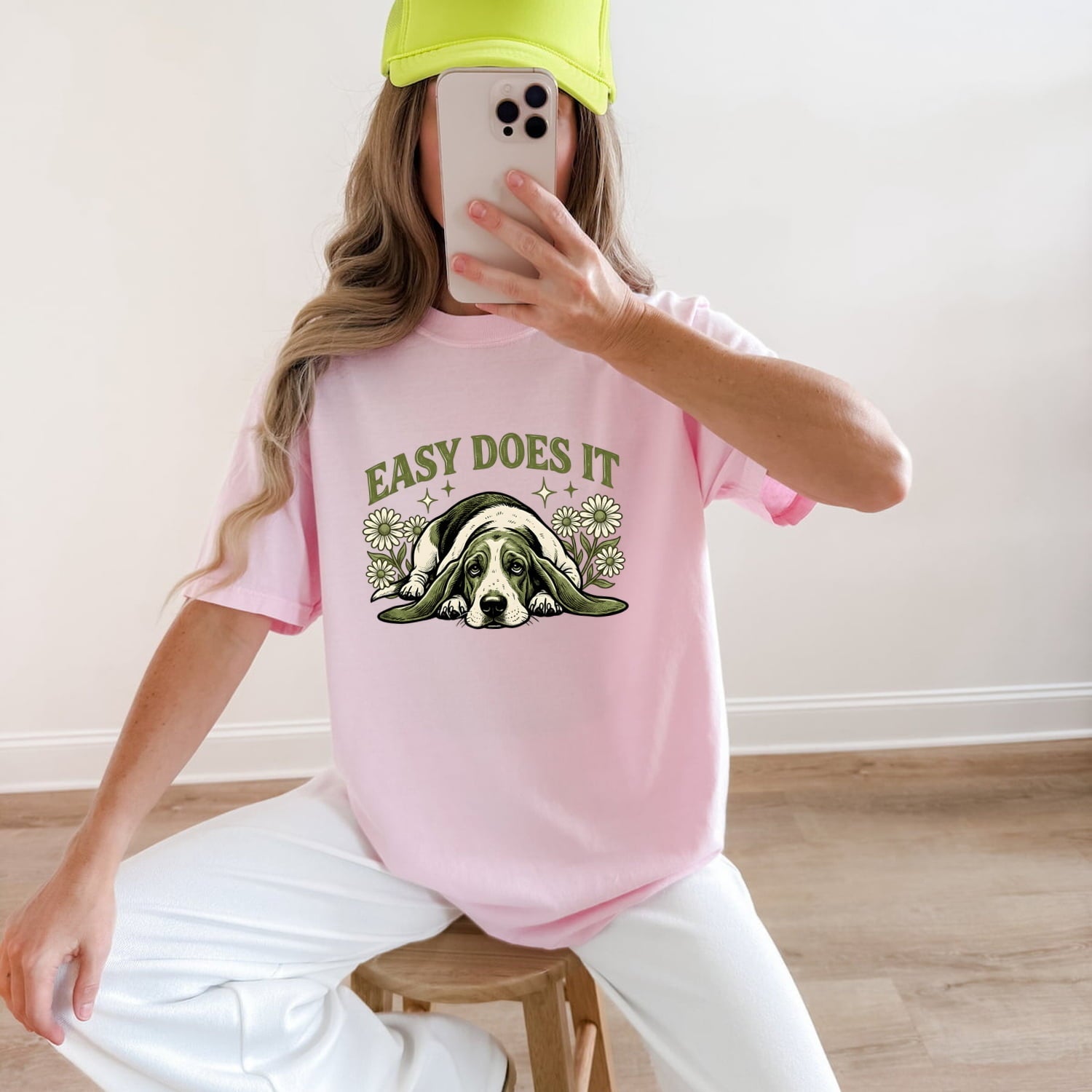 Woman wearing a Blossom Comfort Colors 1717 t-shirt with a dog graphic and 'Easy Does It' text, taking a mirror selfie.