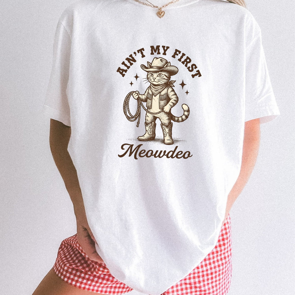 White comfort colors 1717 t-shirt with a cat in a cowboy hat graphic and text on a white background