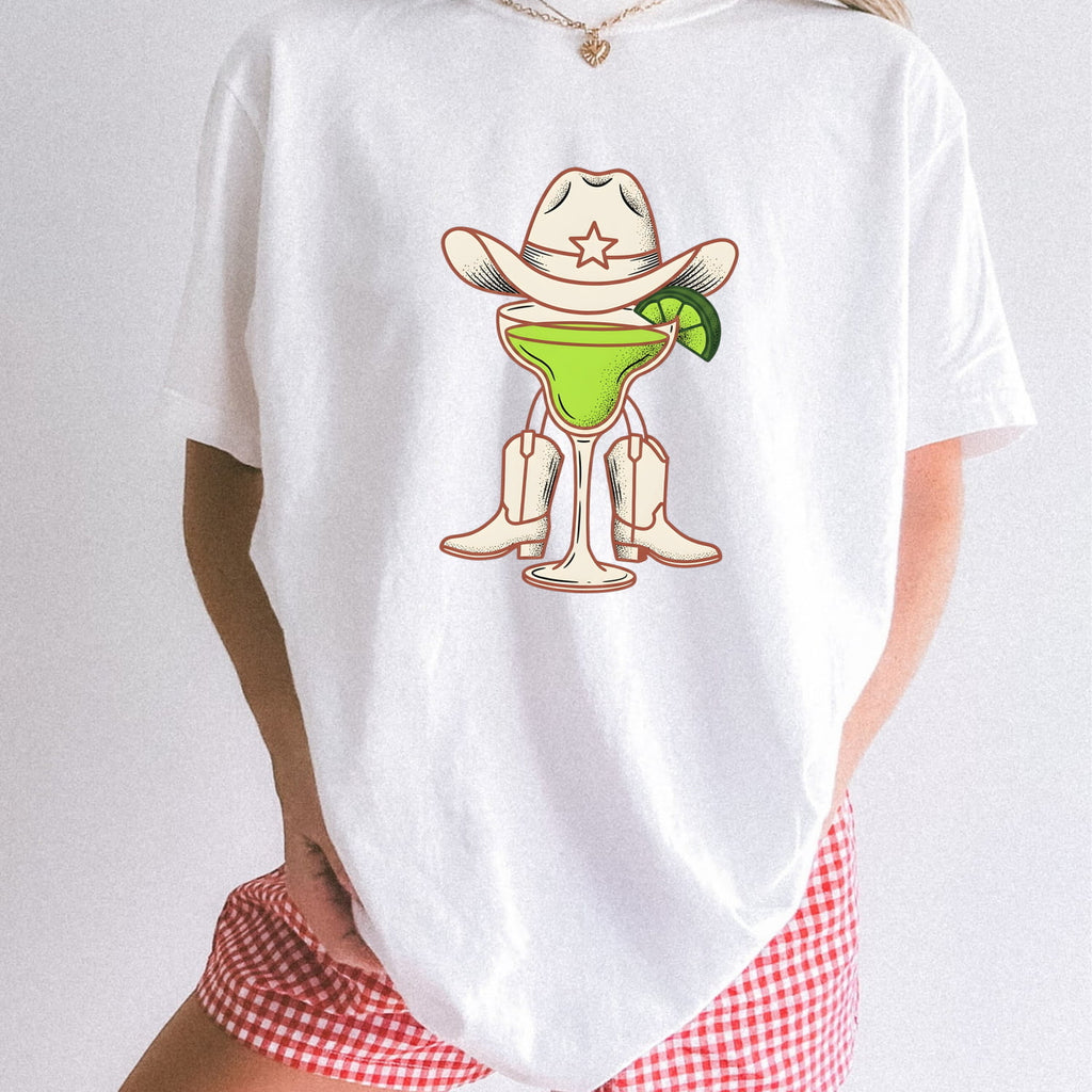 White Comfort Colors 1717 t-shirt with a graphic design of a margarita in cowboy boots and a hat on a plain background.