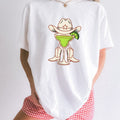 White Comfort Colors 1717 t-shirt with a graphic design of a margarita in cowboy boots and a hat on a plain background.