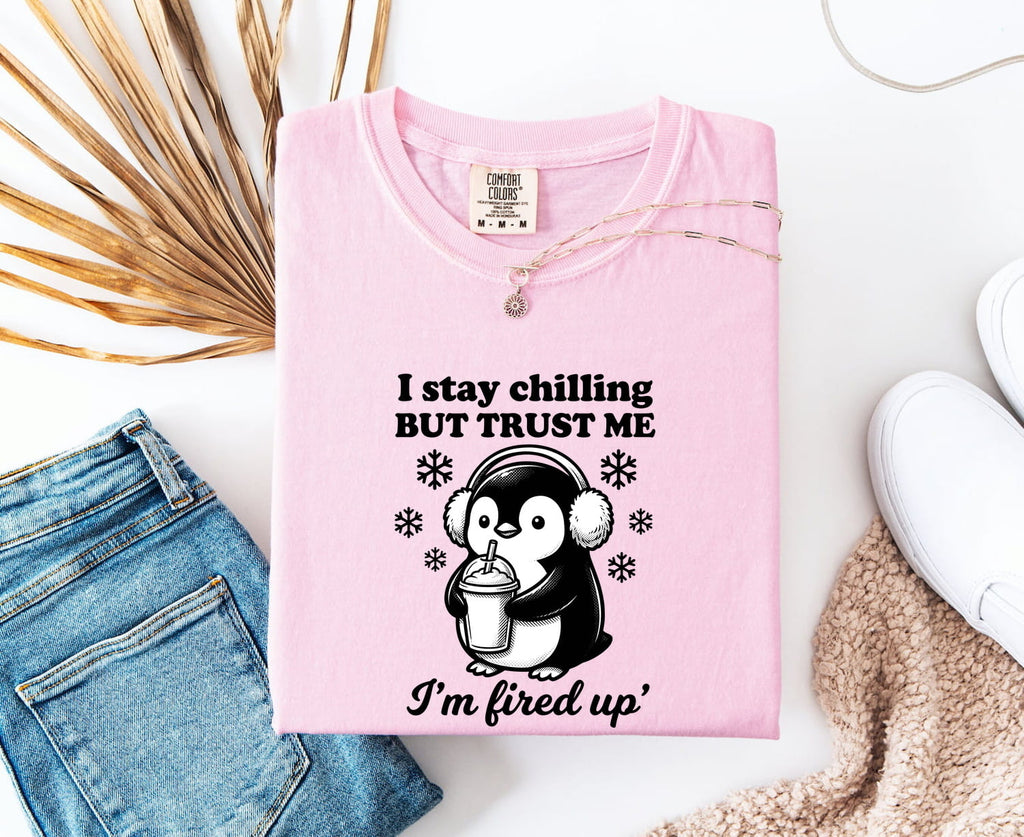 Blossom Comfort Colors 1717 t-shirt with a penguin graphic and funny text on a white surface with jeans and a shoe.