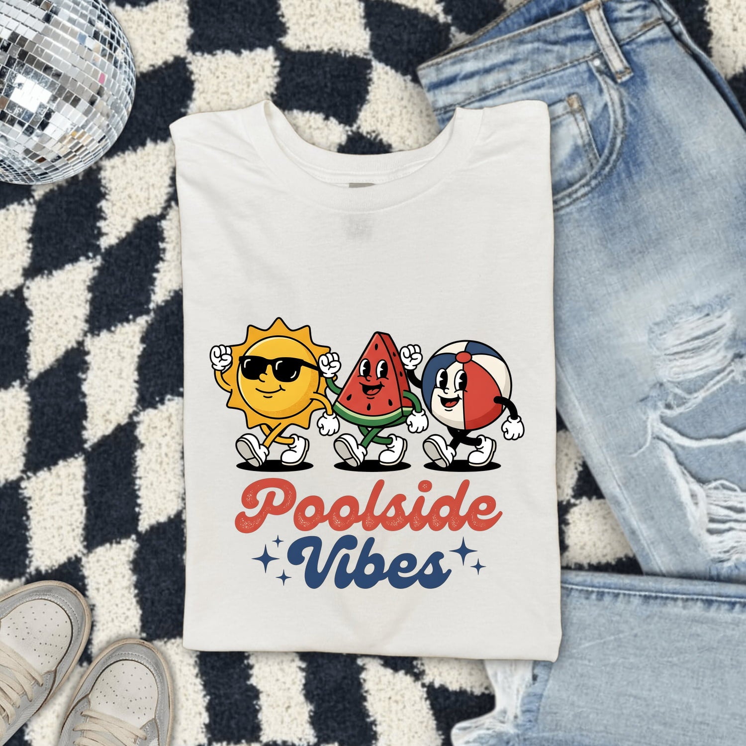 White Comfort Colors 1717 t-shirt with 'Poolside Vibes' design featuring sun, watermelon, and beach ball characters folded on a checkered rug.