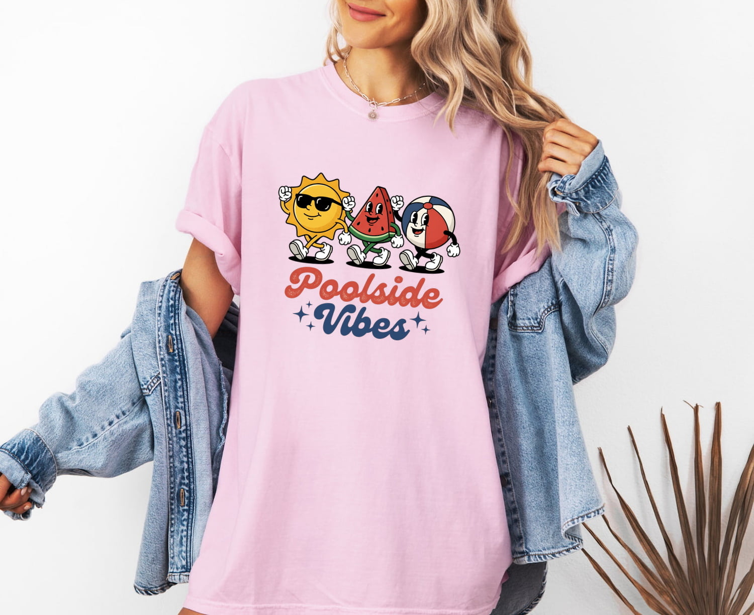 Woman wearing a blossom Comfort Colors 1717 t-shirt with 'Poolside Vibes' text and cartoon graphics, and a denim jacket.