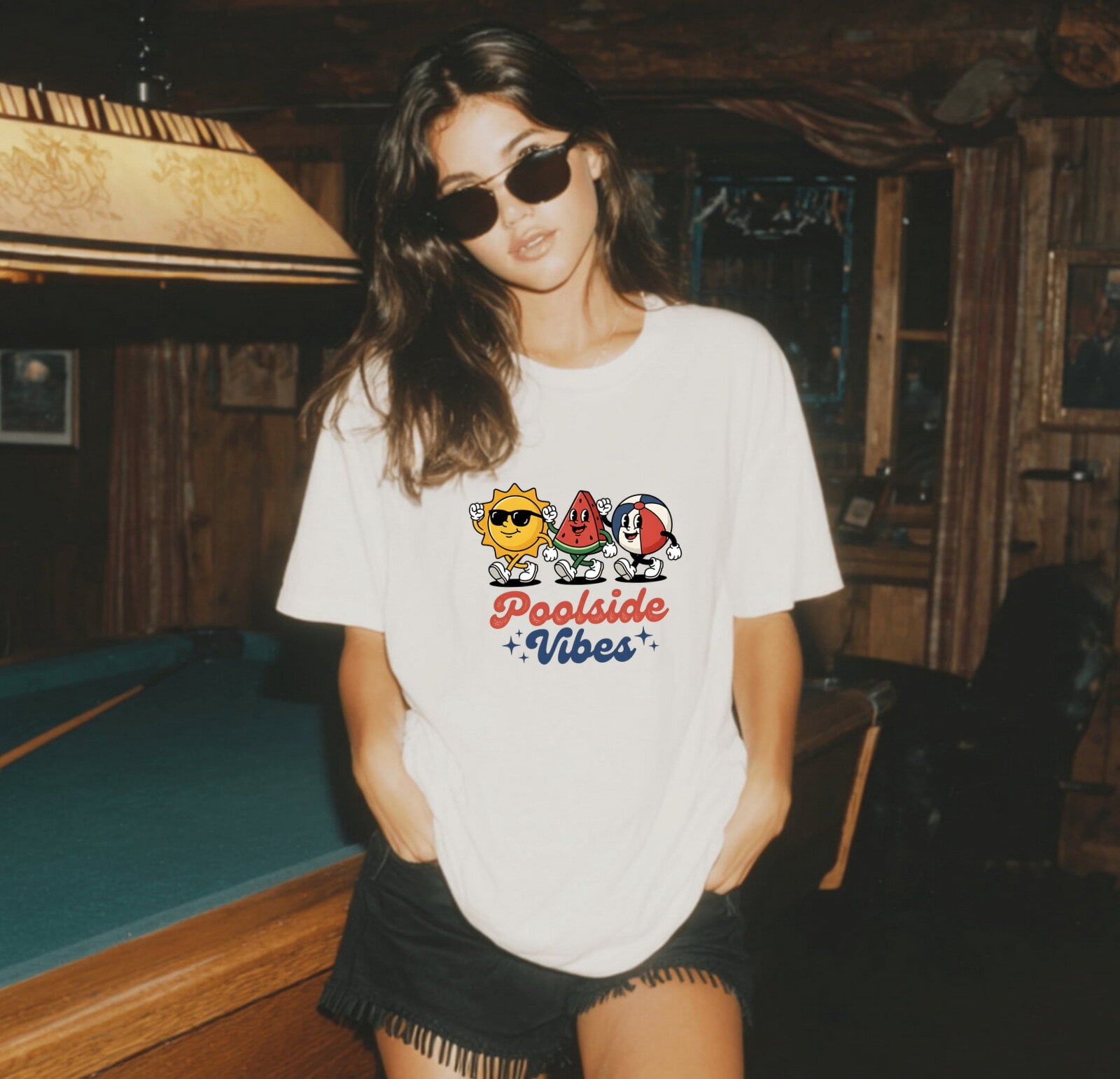 Girl wearing a white Comfort Colors 1717 'Poolside Vibes' t-shirt in a pool hall setting